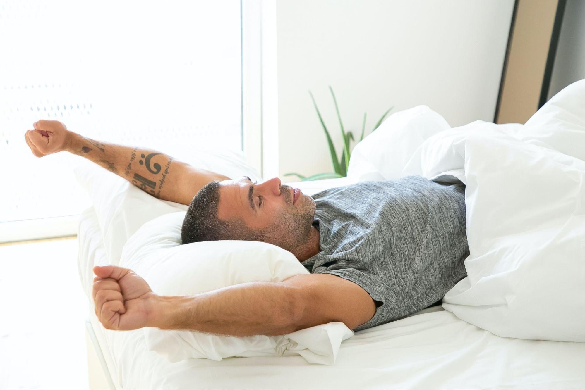 a man stretching in bed