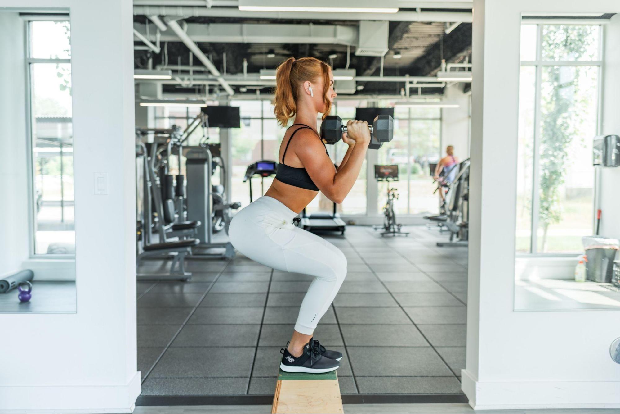 woman holding dumbbells and exercising glutes