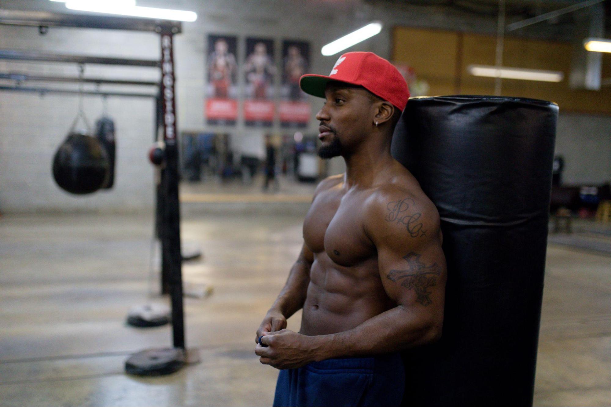 man in the gym next to a boxing punching bag