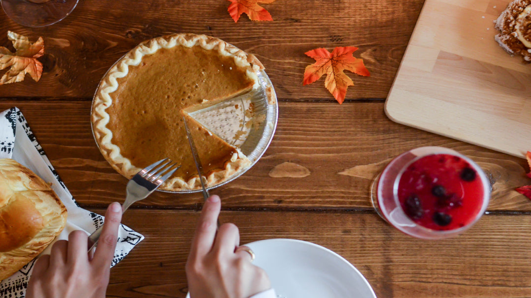 person using fork and knife to cut pumpkin pie