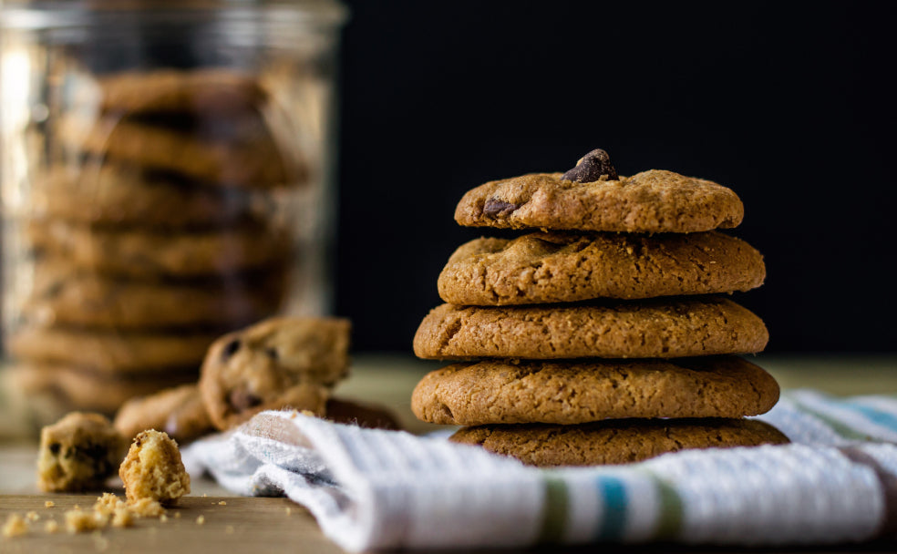 five chocolate chip cookies stacked on top of a kitchen cloth