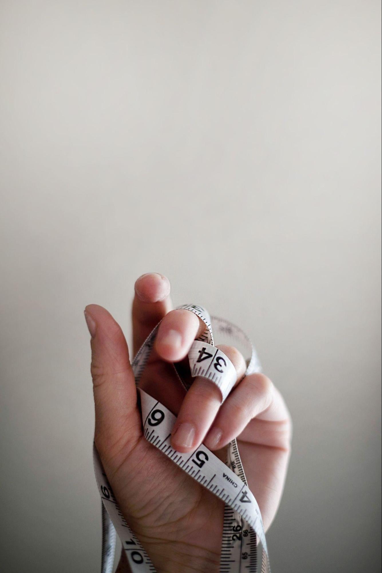 a hand with a body fat measurement tool
