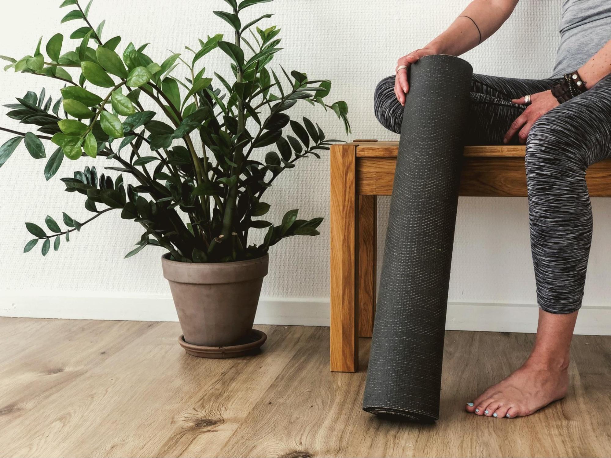 Girl sitting with a yoga mat