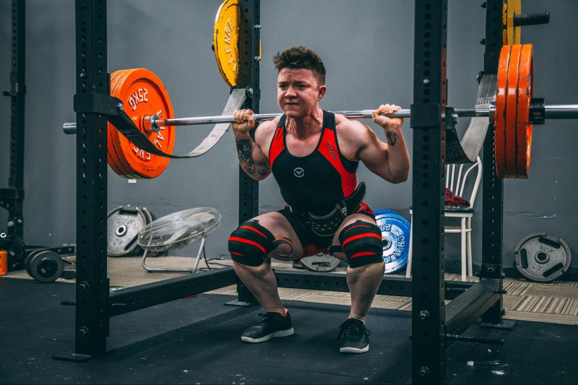 person doing a squat exercise in a gym