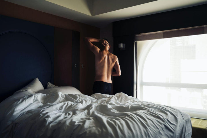 a muscular man getting out of bed