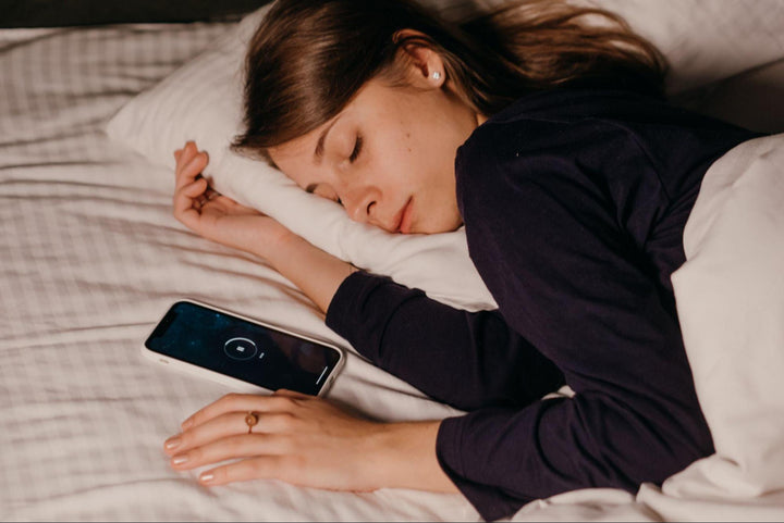 a woman sleeping next to her phone