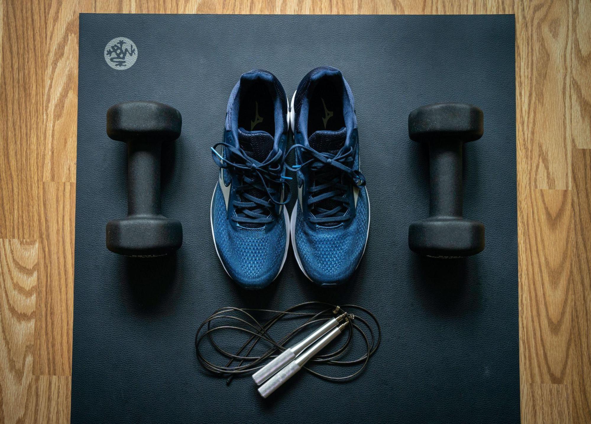 pair of gym shoes next to dumbbells 