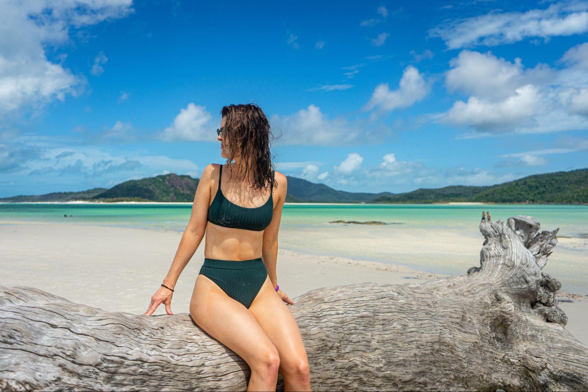  fit woman sitting on a tropical beach