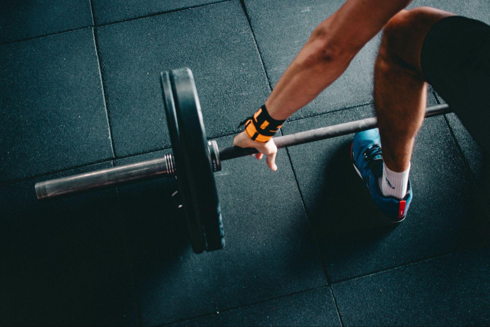 person grabbing a barbell with weights 