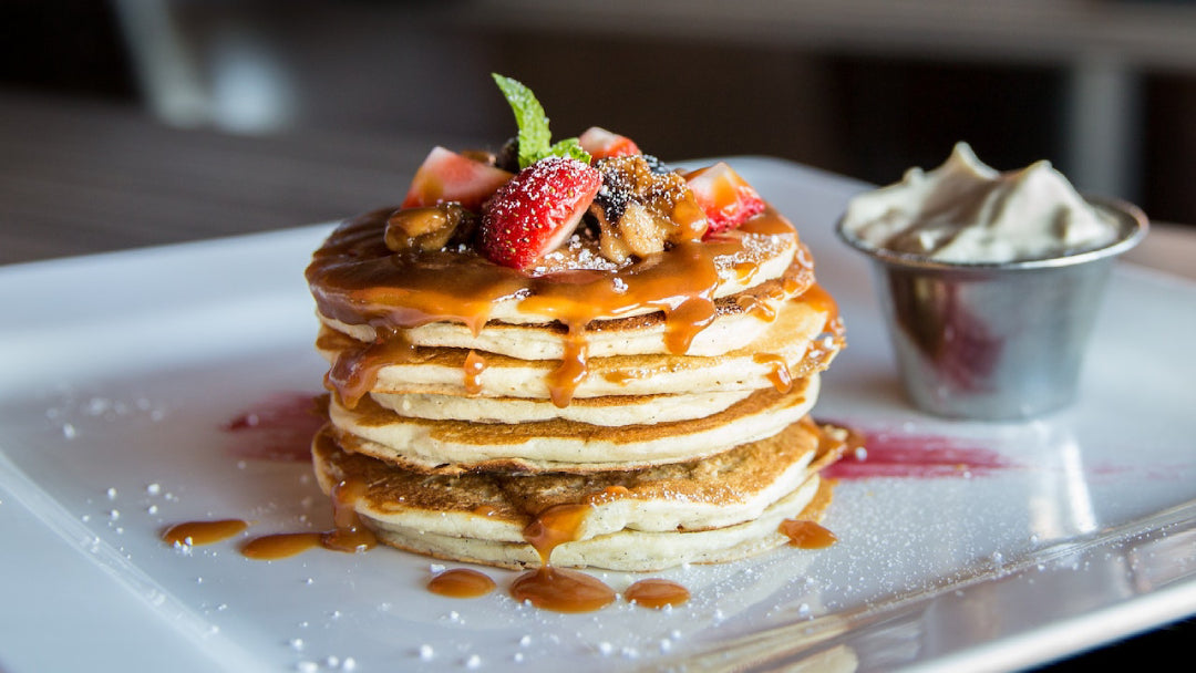pancake on plate with whipped cream on the side